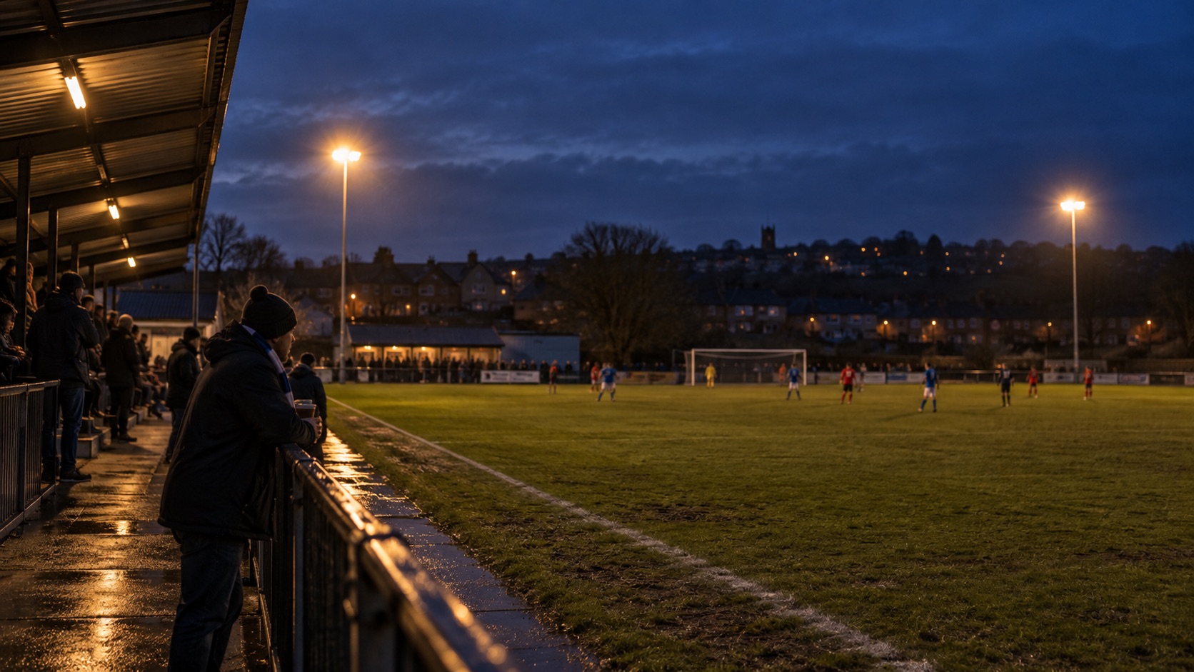 Illustrative scene of supporters beside a small local football ground under floodlights at dusk